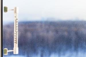 thermometer illuminated by sun in cold winter day photo