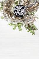 one black glass Xmas ball and twig on blank paper photo