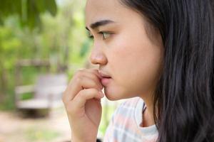 Girl teen nervous anxious feeling bad moody worry gesture face and nail biting photo