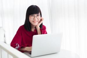 Asian nerdy teen happy smile with laptop computer working women photo