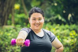 fat girl happy smile with dumbbell sport outdoor exercise for healthy and diet photo