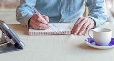 man hand holding a pen to write a book photo