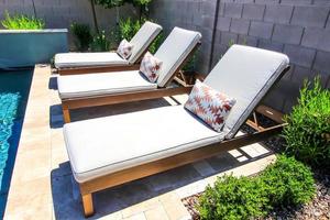 Three Adjustable Lounge Chairs By Swimming Pool photo