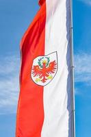 bandera de color rojo y blanco con un escudo que lleva una bandera de águila roja del tirol del sur alto adige oficialmente nombrada provincia autónoma de bolzano en el norte de italia foto