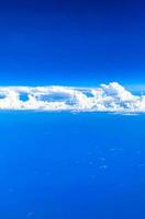 Flying above the clouds with view from the plane window. photo
