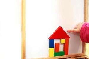 child plays wooden magnetic educational game. girl plays with a toy on a white background. photo