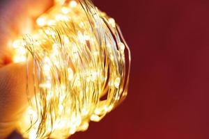 christmas beautifull shiny gold garland on a red background. sparkle festive background photo