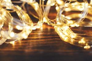 christmas beautifull shiny gold garland on a wooden brown background. sparkle festive background photo