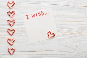 cuaderno con lista de deseos en una mesa de madera vintage con bastones de caramelo. concepto de planificación navideña. foto