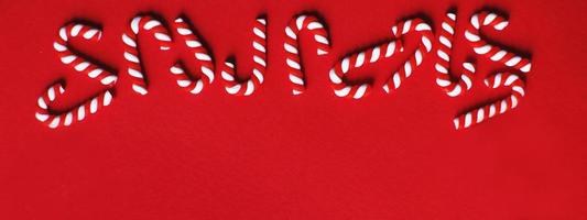 Christmas composition with frame of candy canes on a red background. Copy space for text. banner photo