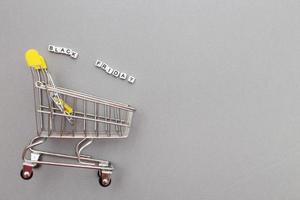 The metal shopping cart on a grey background. black friday sale concept photo