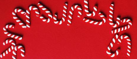 Christmas composition with frame of candy canes on red background. Copy space for text. banner photo