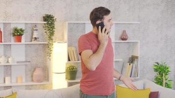 hombre frustrado en casa hablando por teléfono. hombre hablando nerviosamente por teléfono en casa. video