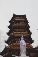 A Pagoda in the center of a Chinatown with the statue of Guan Yin. photo