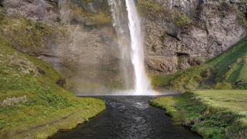 vidéo hd d'une belle cascade avec un arc-en-ciel dans les embruns... filmée en islande. vidéo hd, hdr