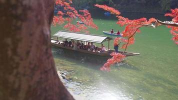 2019-11-23 Kyoto, japan. färgrik arashiyama flod, med turist båt i vatten och skog på flodstränder i höst färger video