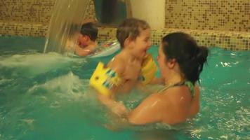 família se divertindo na piscina coberta video