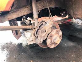 Old rusty worn brake discs, pads of a truck, car. Car suspension repair. Replacing wheel photo