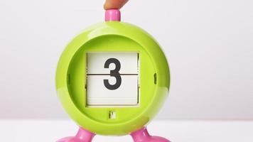 Front view of a green day clock with numerals on a white background. video