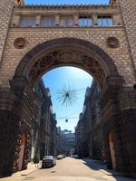 Large ancient vintage architectural stone beautiful arch and a narrow city street photo