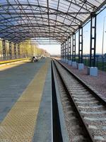 estación de tren moderna, estación de tren con un dosel transparente para pasajeros y rieles foto