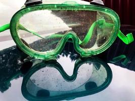 glasses for mowing the lawn. protection of eyes from grass and corneal damage. plastic glasses, green frame with elastic bands on the ears. gardener uniform photo