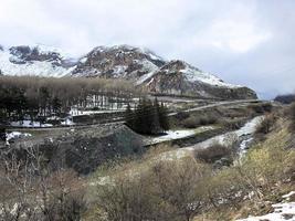 hermosos paisajes de invierno frío de montaña con picos de alta montaña niebla y rocas cubiertas de nieve para el snowboard y el esquí contra un cielo azul foto