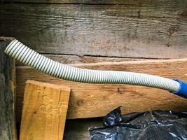 white long pipe with a bend, ribbed, strange shape. plastic pipe, covered with rubber. means for draining and supplying water to the house. DIY plumbing, handmade photo