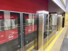 sistema de plataforma de puerta automática en una nueva estación de metro moderna. el sistema de seguridad del metro, hermosas puertas de vidrio, se abren sincrónicamente con las puertas del vagón de tren que llega foto