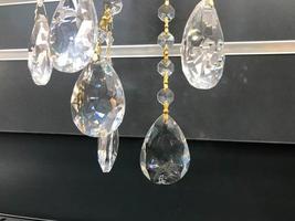 bolas de cristal en la araña. adornos decorativos para crear un estilo de vida individual. lindas bolas de cristal para la lámpara. gotas para candelabro en montura dorada foto