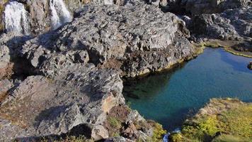 video hd de una hermosa piscina turquesa con pequeñas cascadas en el fondo. tiro en islandia. vídeo de alta definición