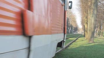 rood en wit tram in beweging Aan een spoor, bediend door de daugavpils tram systeem, gelegen in daugavpils, Letland. video