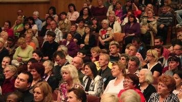 multitud sentada en la audiencia viendo un espectáculo, video