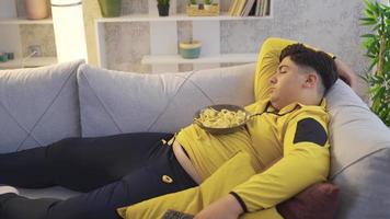 exceso de peso, problema de salud, obesidad. niño obeso que consume alimentos mientras duerme.