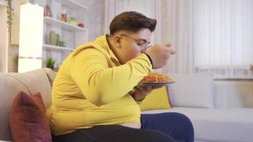 mangiare piacere di il sovrappeso bambino. sovrappeso ragazzo mangiare pasta. lui gli amori cibo. video