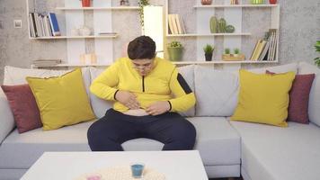 Obese overweight boy. Obese child looking at his belly, unhappy at home. video