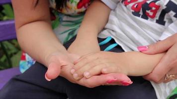 close up of mother hands stroking her child, when he sits in her arms video