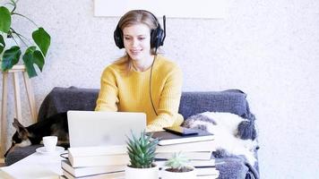 Distance learning. E-learning. Business. Young woman using laptop chatting online, having video call and drinking coffee