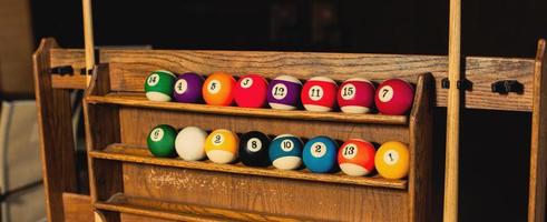 Set of balls for a game of pool billiards on shelves photo