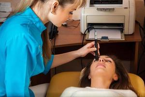 lovely young adult woman patient checks eyesight ophthalmologist photo