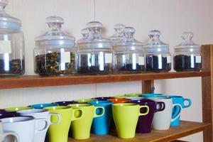 colorful cups and a lot of varieties of tea on the shelves photo