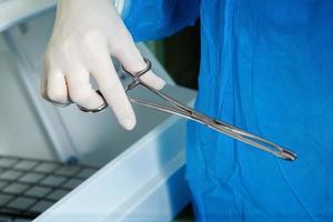 Photo forceps in the hands of doctor in latex gloves