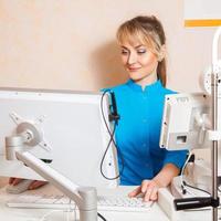 square portrait of beautiful young adult doctor works at computer photo