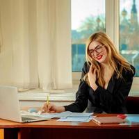 office worker writes the paper and talking on the phone photo