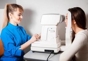 ophthalmologist checks eyesight at her patient with a slit lamp photo