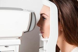 beautiful young girl checks eyesight on Autoceratorefractometers photo