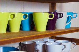 set of colorful cups on the shelf photo