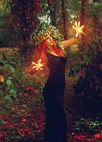 fantastic young witch conjures in the forest photo