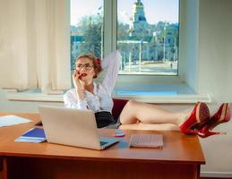 portrait of beautiful young secretary working from desk talking on cell phone photo