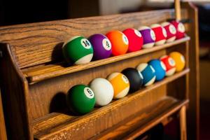 Horizontal photo of Set of balls for a game of pool billiards on shelves